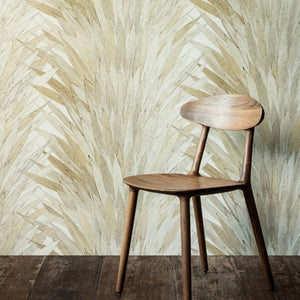 beige textured wallpaper that has a leaf pattern. There is chair in front of the wall. Dark wooden floor