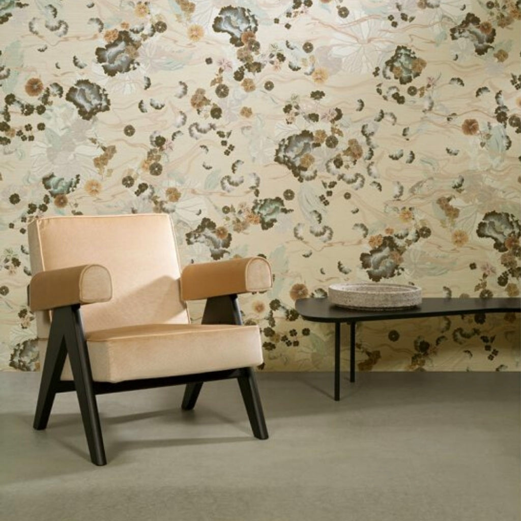 japan inspired pattern on a wall, with cream and soft green colors. There is a cream leather armchair standing in front of the wall and a black glossy table. 