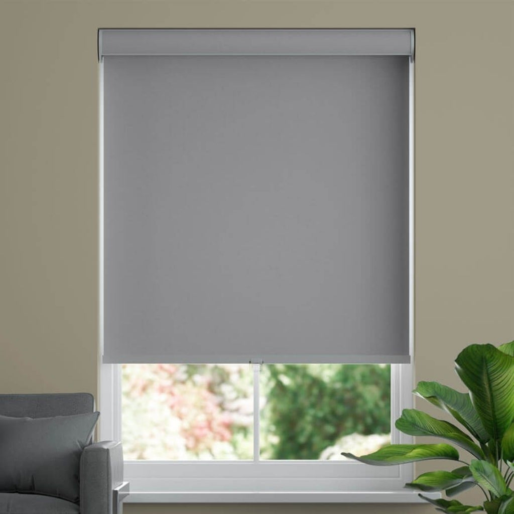 Light Graz roller shades, on a closed window. Gray sofa on the right side of a room. 