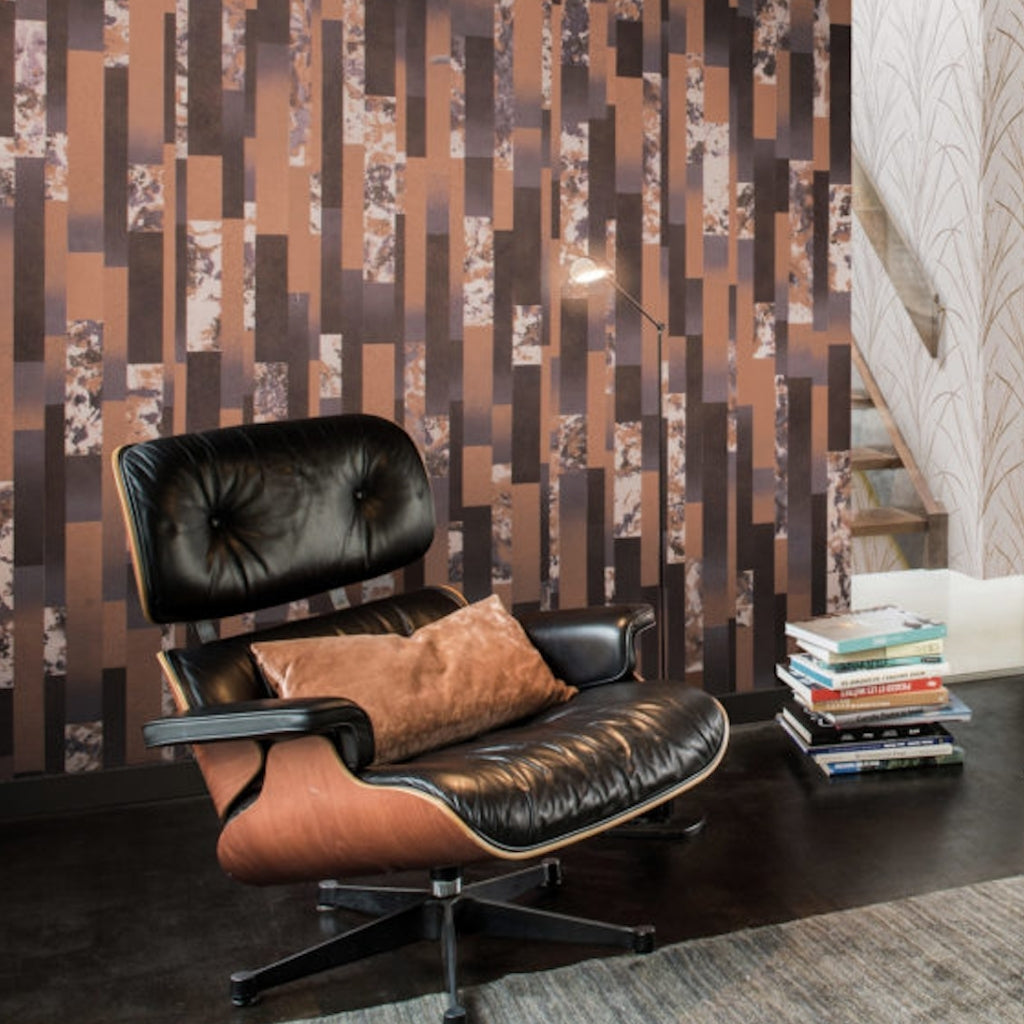 black leather chair with multi-coloured wallpaper on the wall