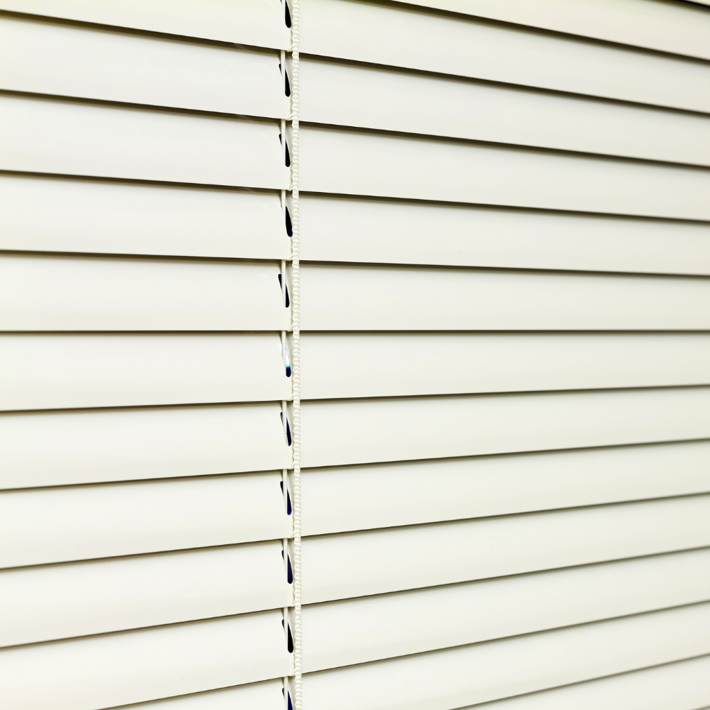 Close up photo of white aluminum blinds. They are closed.