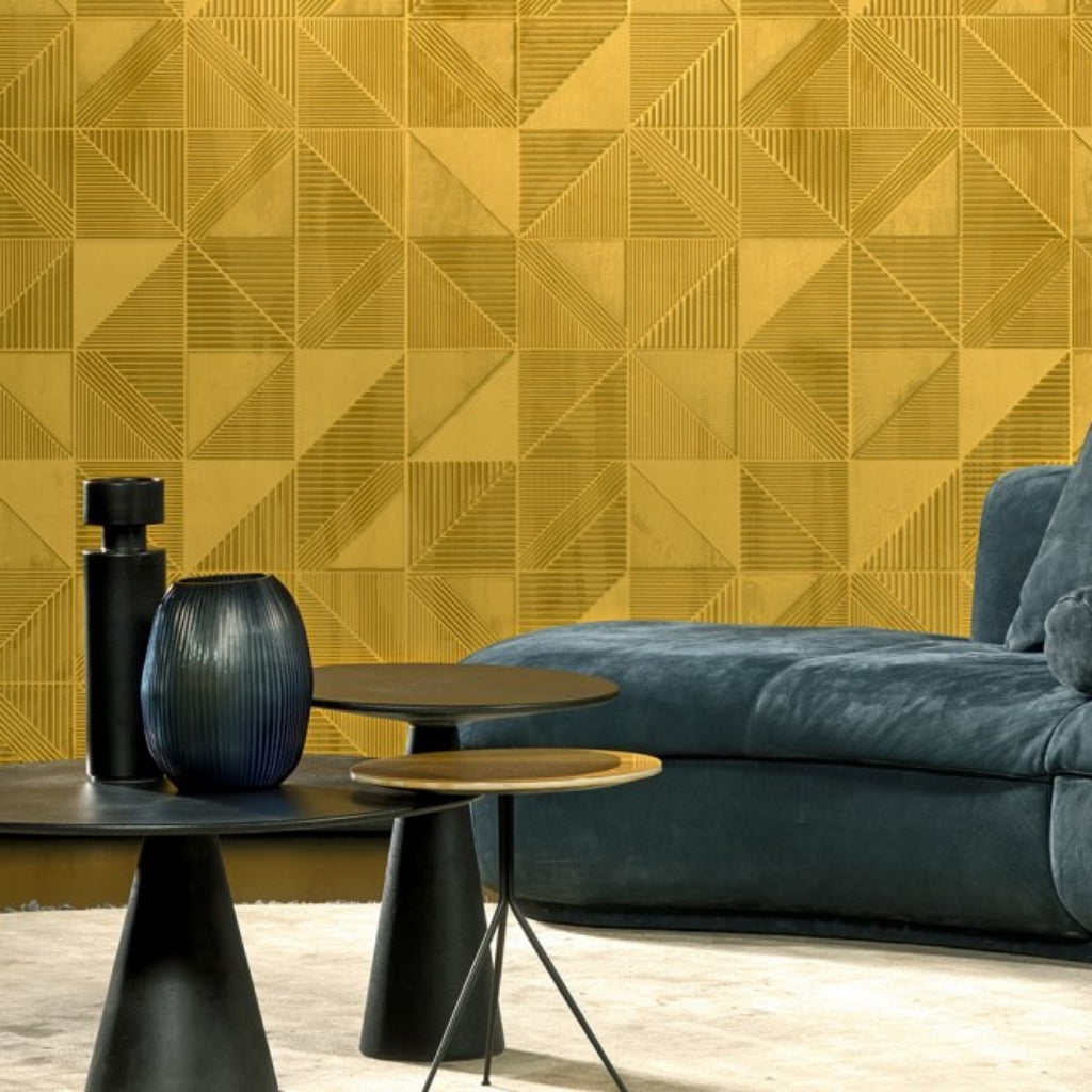 yellow geometric wallpaper. black coffee table and blue velvet couch.